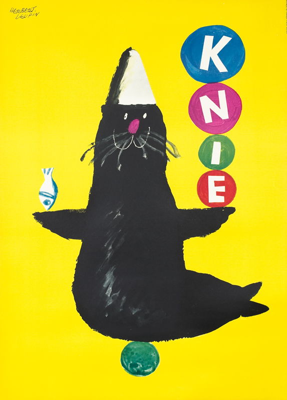 Cartoon seal balances four balls that together spell KNIE;  yellow, black, red