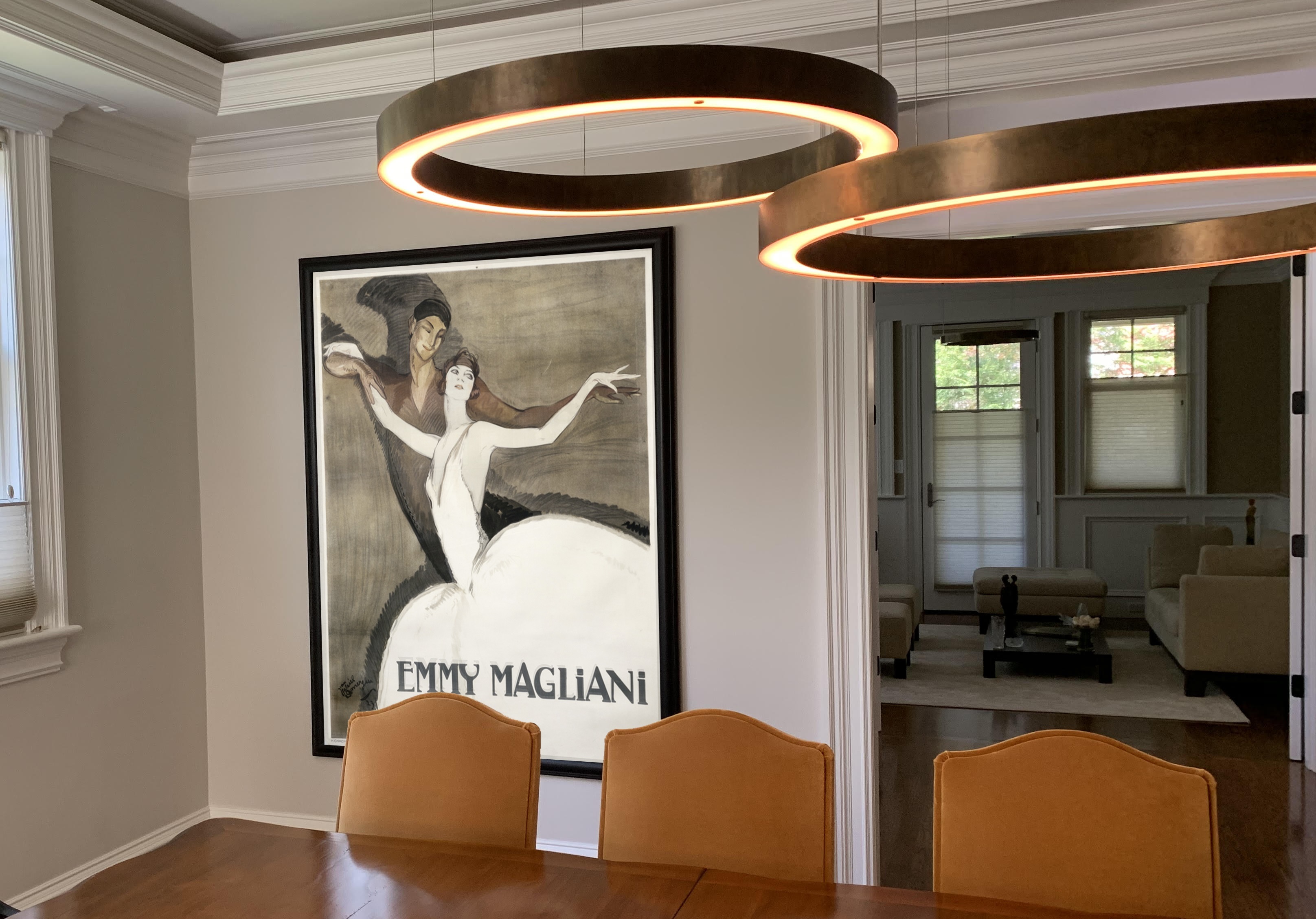 warm dining room with abstract lights and poster with man and woman ballet dancers; brown, white, orange
